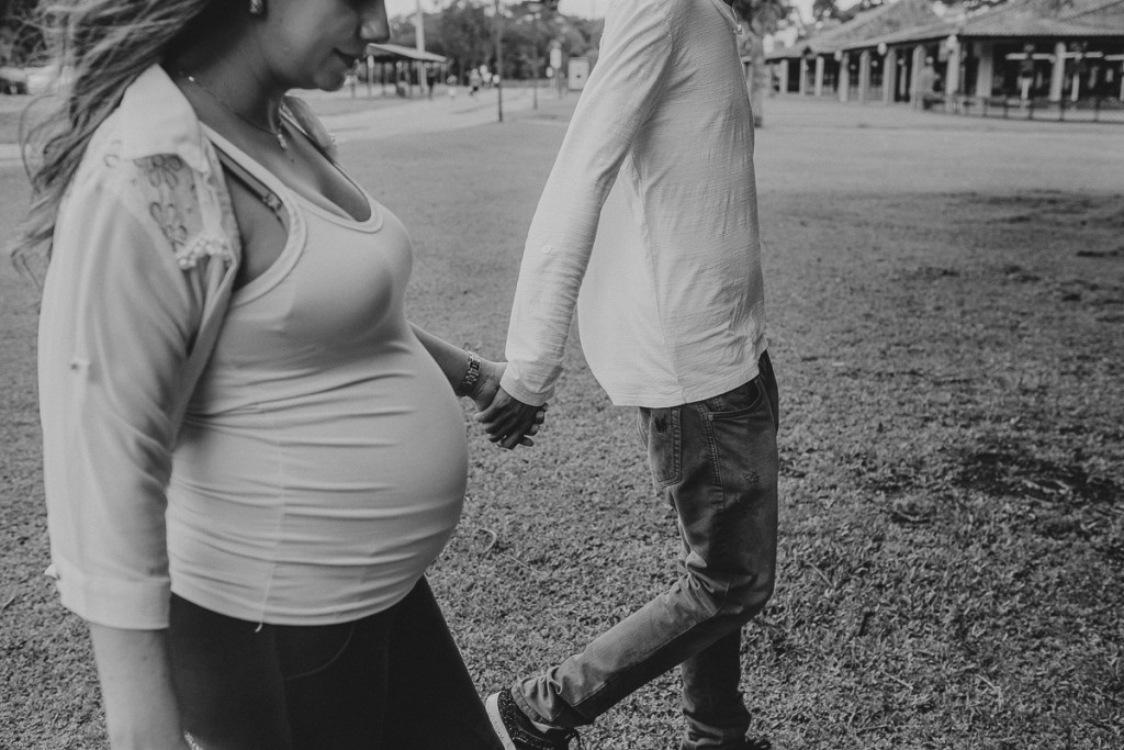 casal gravidos andando de mão dadas.